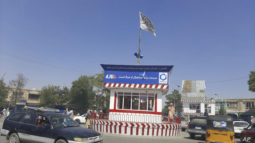 A Taliban flag flies in the main square of Kunduz city after fighting between Taliban and Afghan security forces, in Kunduz, Afghanistan, Sunday, Aug. 8, 2021. Taliban fighters Sunday took control of much of the capital of northern Afghanistan's Kunduz province, including the governor's office and police headquarters, a provincial council member said. (AP Photo/Abdullah Sahil)