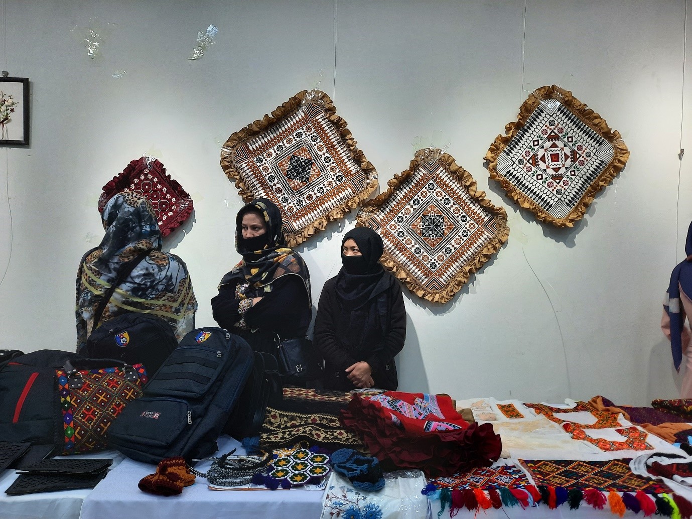 زنان غرفه‌دار در حال فروش صنایع دستی شان در نمایشگاه است. عکس: رسانه‌ی رخشانه.