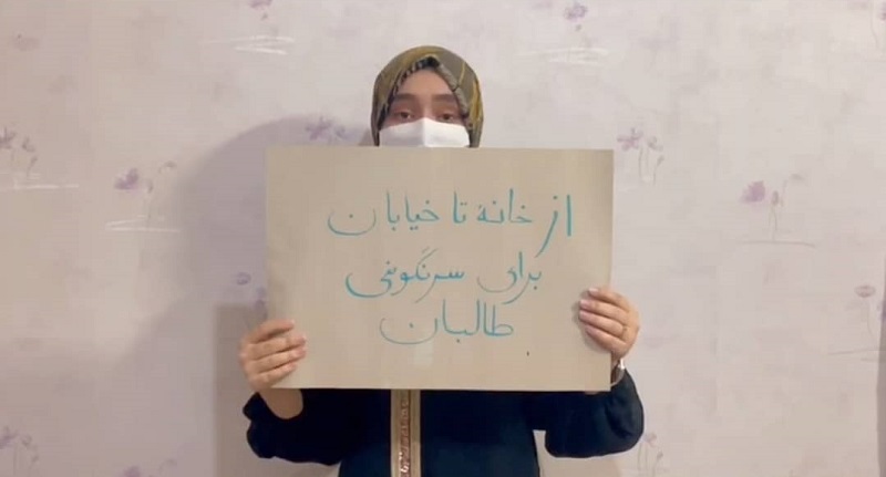 یک خانم معترض با پلاکارت اعتراضی، عکس: ارسالی